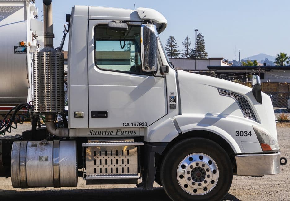 A white Volvo VNL day cab parked on an industrial lot